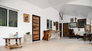 A spacious interior with a large window, a wooden door, and a stone bench. - amalfi surf lodge  (Chiltiupan)
