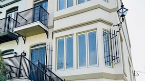Un edificio a più piani con una scala centrale, ampie finestre e un balcone.