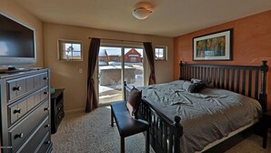 Un dormitorio con una cama, un aparador, un banco y un televisor.
