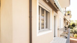 Asuinrakennus, jossa on laatoitettu parveke, ikkuna ja ovi.