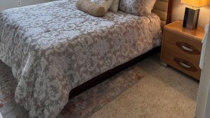 A bedroom with a bed, bedside lamps, a ceiling fan, a window with curtains, and a wall-mounted picture. - Gorgeous 1-bedroom condo close to work and play only steps to beach (Satellite Beach)