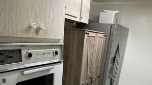A kitchen with a built-in oven, a refrigerator, and wooden cabinets. - Gorgeous 1-bedroom condo close to work and play only steps to beach (Satellite Beach)