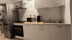 Une cuisine moderne équipée d’un four encastré, d’un four à micro-ondes, d’un grille-pain et d’un évier.