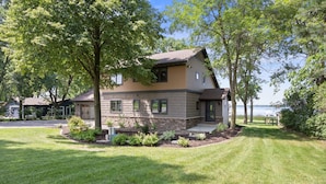 A two-story house with a stone facade, a front porch, and a well-maintained lawn.