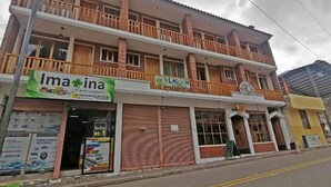A two-story building with a sign for 'Imaña' and 'Lagoon' on the ground floor. - LAGOON HOTEL (Chugchilan)