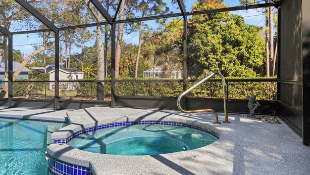 Área da banheira de hidromassagem com vista desimpedida para as árvores ao redor e piscina cercada.