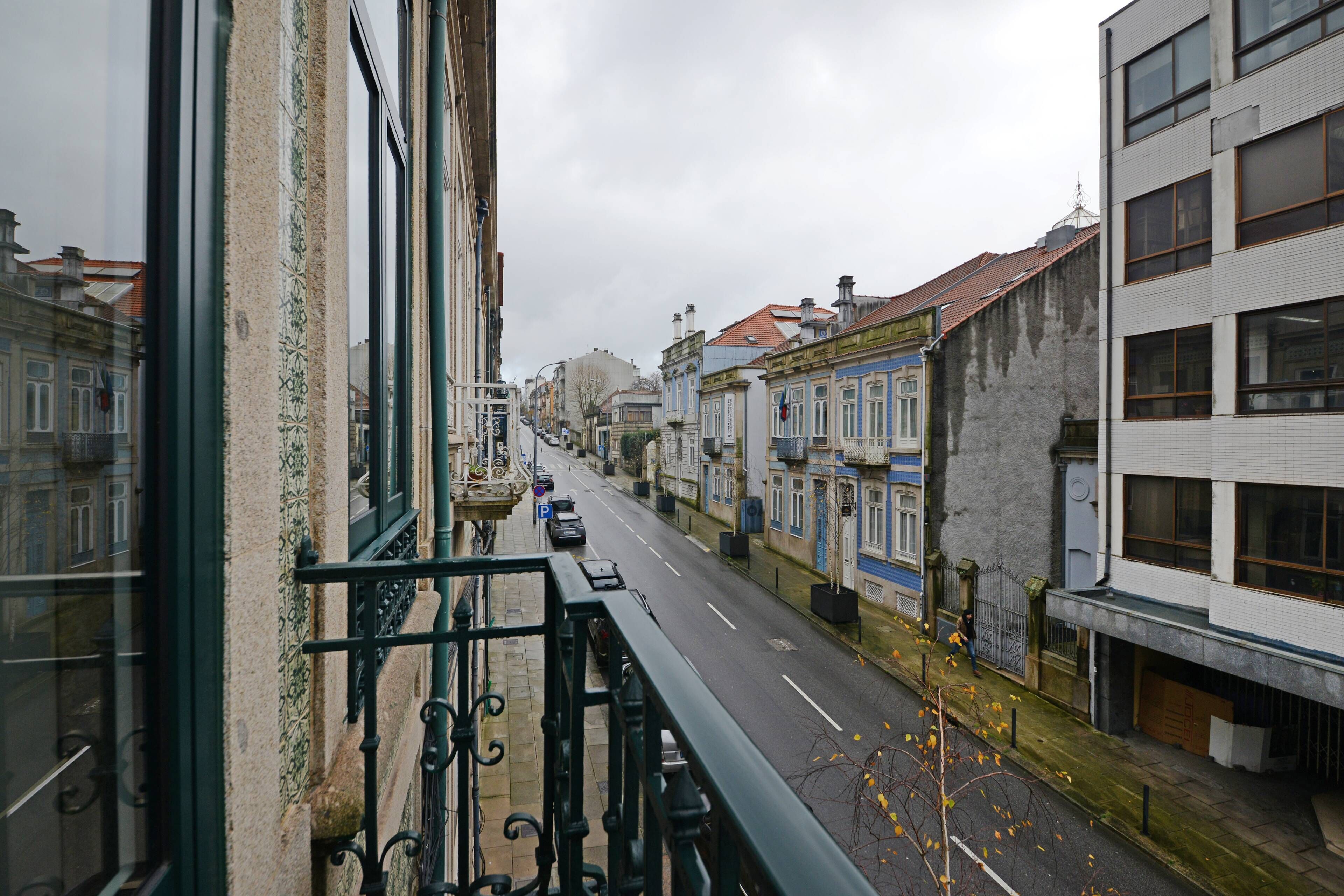 A street view with buildings on either side, a clear road, and a pedestrian walkway.
