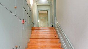 Eine Holztreppe mit Handlauf, die zu einer Tür oben führt.
