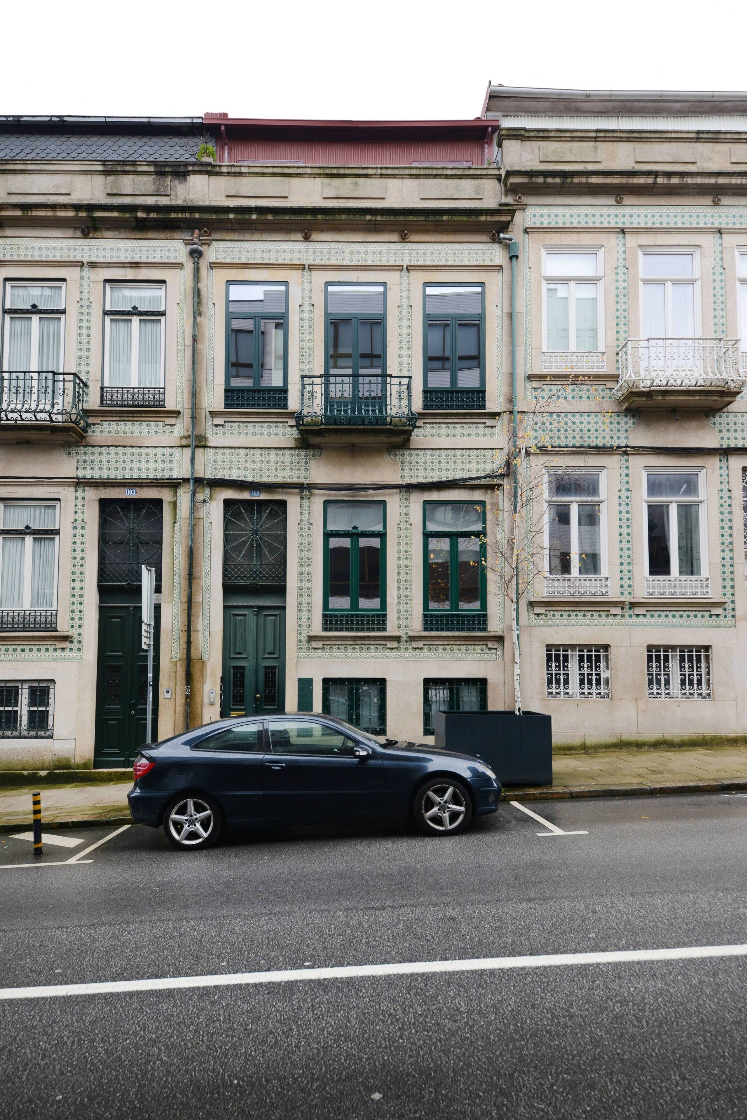 Un edificio de varios pisos con un coche estacionado al frente.