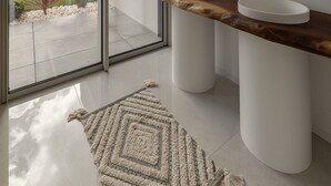 A modern bathroom with two sinks, a large mirror, and a view of a garden through a sliding glass door. - Lagoon Residence 56 Deluxe - Premium Accommodation (Óbidos)