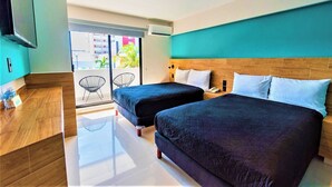Hotelkamer met twee bedden, een houten hoofdbord, een flatscreen televisie, een balkon met stoelen en uitzicht op gebouwen.