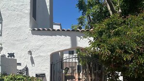 A white building with a gated entrance, a brick pathway, and surrounding greenery. - 3 Bedroom Plus 2 Baths in Beverly Hills (Beverly Hills)