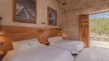 A room with two beds, wooden headboard, and two framed pictures on the wall.