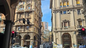 Vista de una calle con edificios históricos, un paso de peatones y un semáforo.