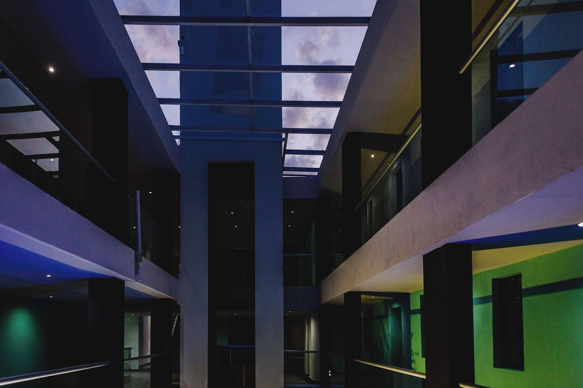 Un interior de diversos nivells amb un atrium central, parets de vidre i un fanal.