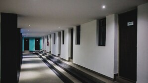 A long, narrow hallway with a series of doors on one side and a staircase on the other. - Your Downtown Hub for Fun and Exploration: 4 Spacious & Relaxing Rooms in Merida (Mérida)