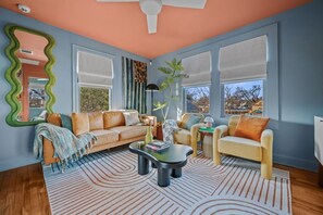 A living room with a sofa, armchairs, a coffee table, and a large mirror. - Chic East Austin Retreat | 2BR | Walkable (Austin)