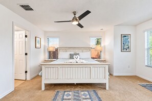 A bedroom with a large bed, a ceiling fan, and two bedside lamps. - Home with Screened Private Pool and Preserve Views (Davenport)