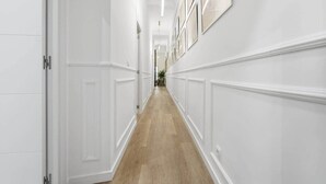 A hallway with white wainscoting and a wooden floor. - Classic Malasaña (Madrid)