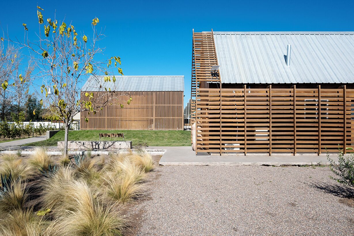 A modern building with a metal roof and wooden slatted walls.