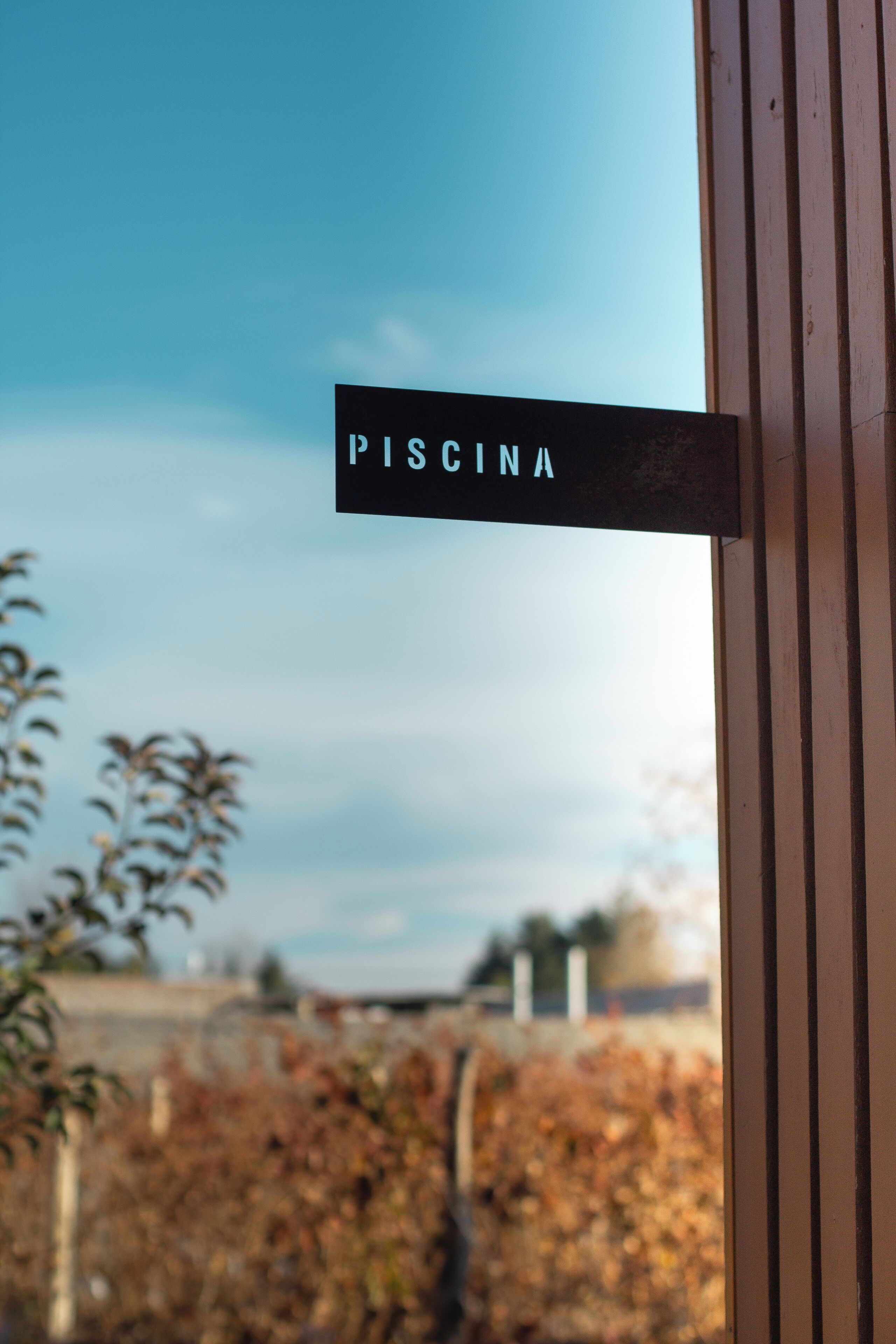 Un letrero con la palabra 'PISCINA' colocada sobre una estructura de madera.