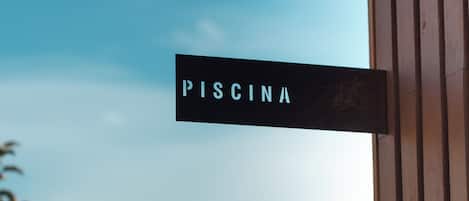 Un letrero con la palabra 'PISCINA' colocada sobre una estructura de madera.