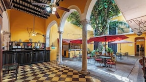 A spacious indoor area with a checkered floor, multiple tables and chairs, and a bar area with a counter. - 2 Bright Rooms in the Heart of the City, Perfect for Families or Friends (Mérida)