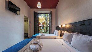 A hotel room with two beds, a wooden headboard, a ceiling light, and a view of the outside. - 2 Bright Rooms in the Heart of the City, Perfect for Families or Friends (Mérida)