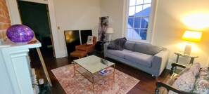 Ein Wohnzimmer mit einer Couch, einem Couchtisch, einer Lampe und einem Kamin.