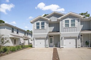 A two-story residential building with a garage, a front porch, and a well-maintained lawn. - 3bd Home! Mins to Beach, Shops, Golf, EV Charger (SANTA RSA BCH)