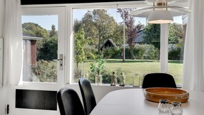 A dining area with a table, chairs, and a view of a garden and a small building. - Stunning home in Sydals with WiFi (Sydals)