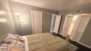 Ein Schlafzimmer mit einem Bett, einem Nachttisch, einer Lampe und einem Kleiderschrank.