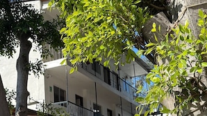 A multi-story building with balconies, a stairwell, and a tree in the foreground. - Motel del Bosque (Tijuana)