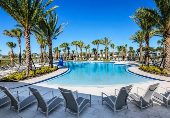 A swimming pool with lounge chairs, surrounded by palm trees. - Luxury Oasis: Golf Cart, Hot Tub, Private Lanai (The Villages)