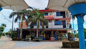 A multi-story building with a sign reading "TERKA" and a visible storefront. - Hotel Volga (Puerto Lopez)