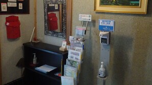 En reception med disk, et billede af et bjerg i ramme, et skilt med japansk tekst og en QR-kode.