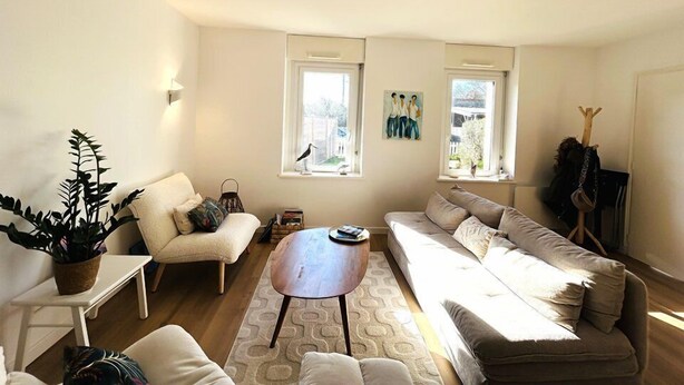 A living room with a sofa, a coffee table, and a small table with a plant. There are two windows with artwork above them. - Cozy stone house for 3 people, 5 minutes from the beaches, with Wifi (PLOEMEUR)