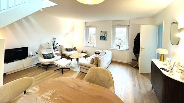 Ein modernes Wohnzimmer mit Fernseher, Sitzecke und Essbereich.