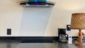 Una cucina con piano cottura moderno, macchina per il caffè e cappa aspirante integrata.