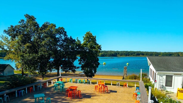A lakeside patio with outdoor seating and a view of the lake.