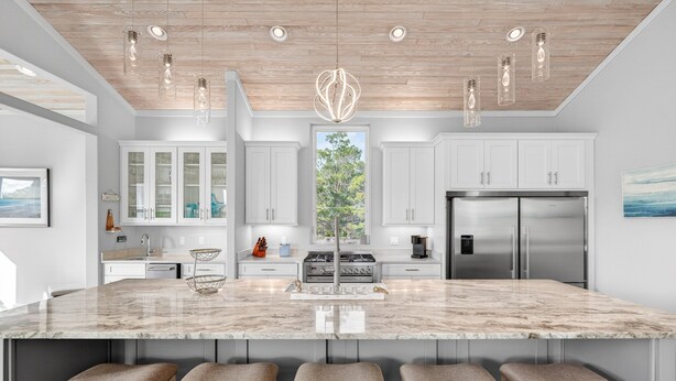 A modern kitchen with a large island, stainless steel appliances, and pendant lighting. - Coastal Sunsets - Vacation Rental in 30A with Private Pool (Santa Rosa Beach)
