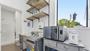 Una kitchenette compacta equipada con microondas, tostadora y cafetera.