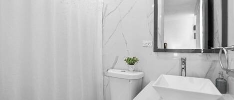 Un baño moderno con ducha, inodoro y lavabo.