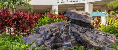 A hotel with a rock garden and a waterfall feature.