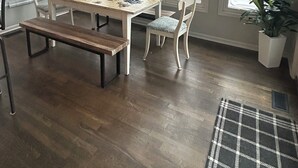 A dining area with a wooden table and chairs, a ceiling fan, large windows with a view of trees, and a plaid rug on the floor. - Welcome World Cup fans to this Spacious 5-bedroom house with Modern updates (Overland Park)
