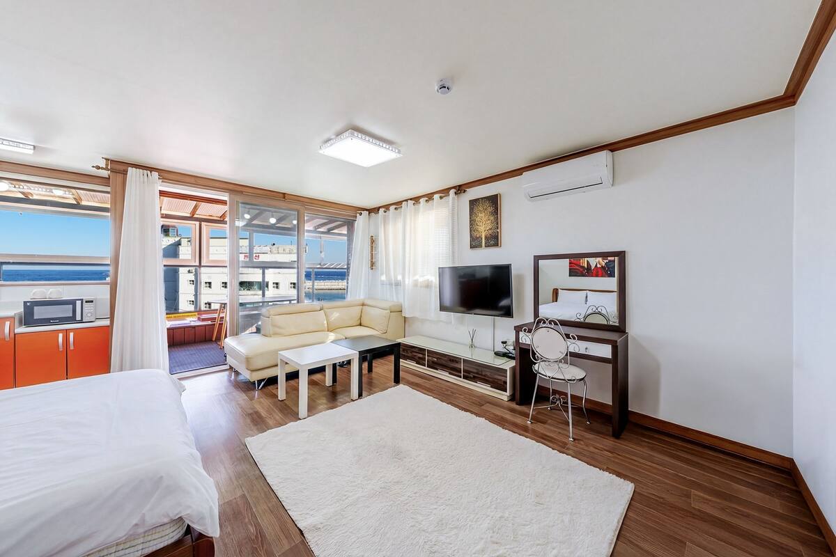 Une chambre d’hôtel moderne équipée d’un lit, d’un canapé, d’une télévision et d’un coin repas.