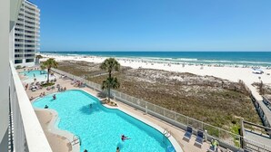 Área da piscina com vista para a praia e o oceano.