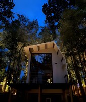 Um edifício moderno com telhado plano, grandes janelas e fachada simétrica.