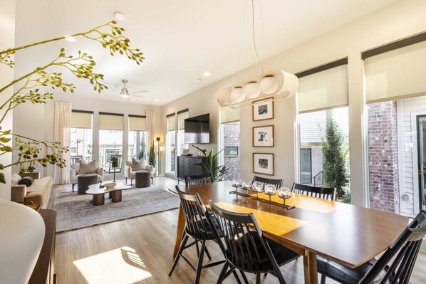 Un salón comedor amplio, con grandes ventanales y chimenea.