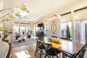 Un salón comedor amplio, con grandes ventanales y chimenea.